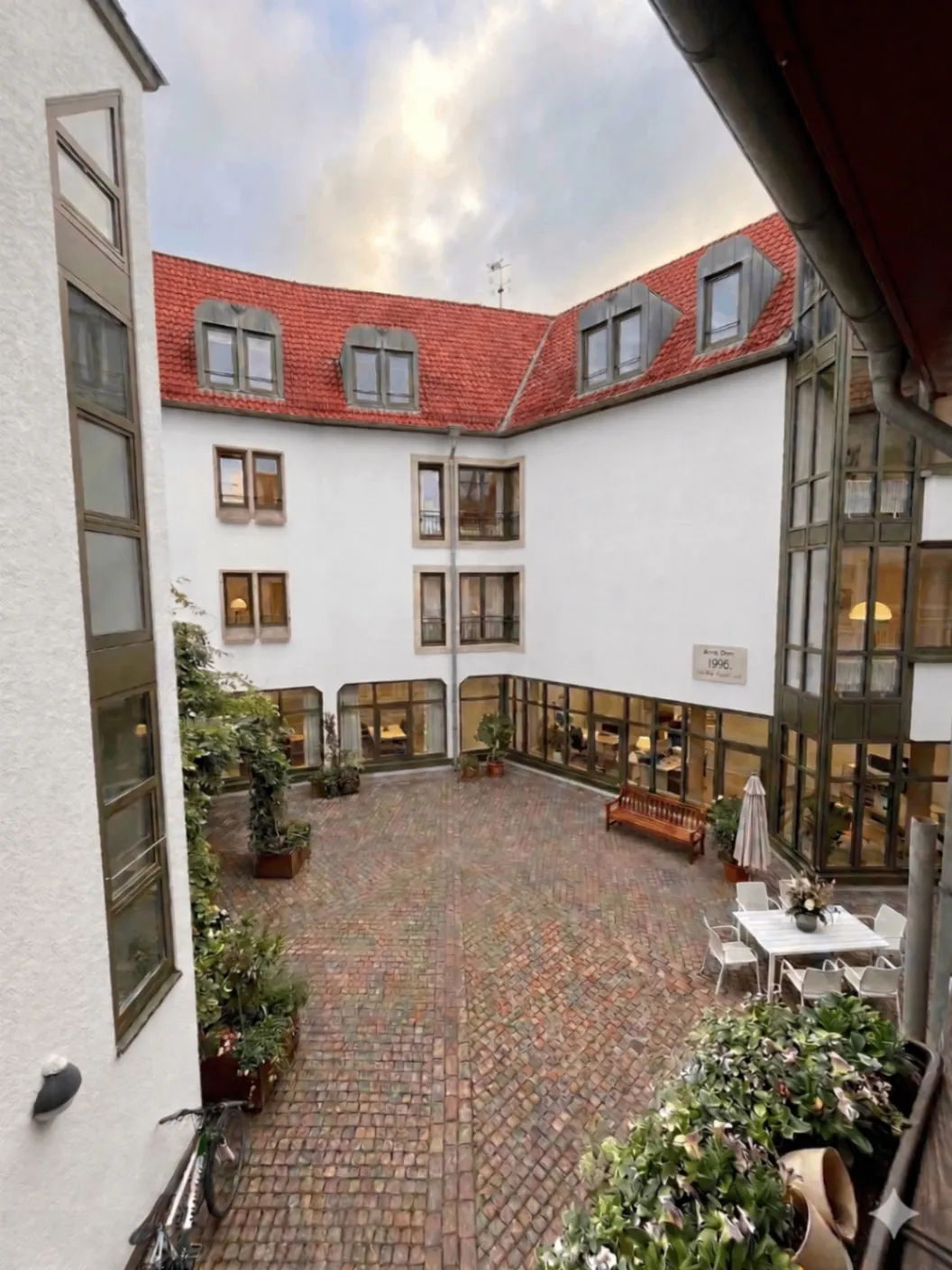Ruhiger Innenhof mit Pflanzen und Sitzgelegenheiten
